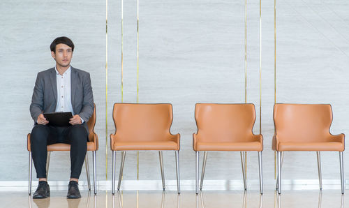 Businessman looking away while sitting on seat in office