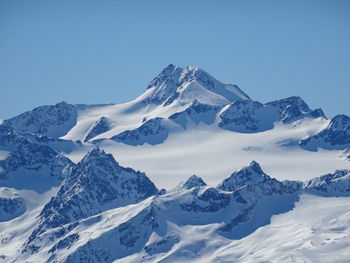 Scenic view of snowcapped mountains against clear blue sky