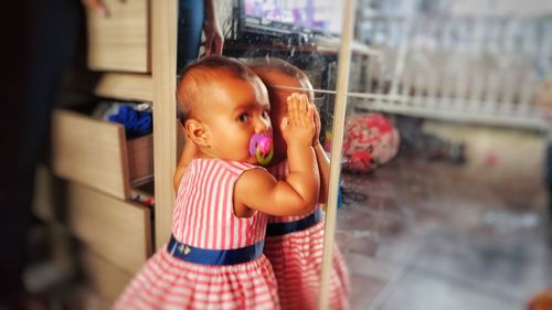 Cute baby girl standing indoors