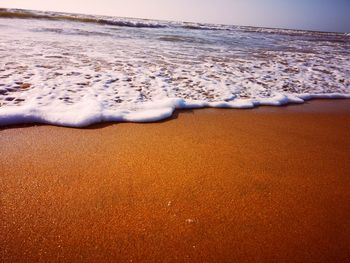 Surface level of sandy beach against sky