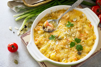 Casserole crumble with red fish, white bread and cheese on stone or slate background. 