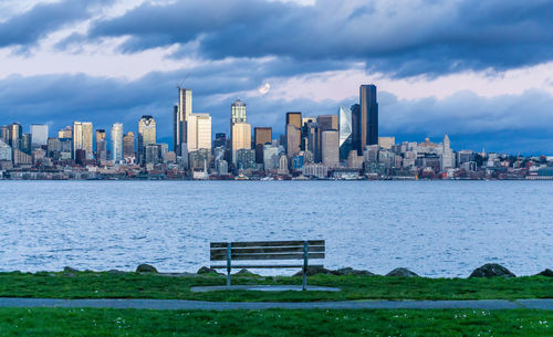 A full moon shines above the seattle skyline.