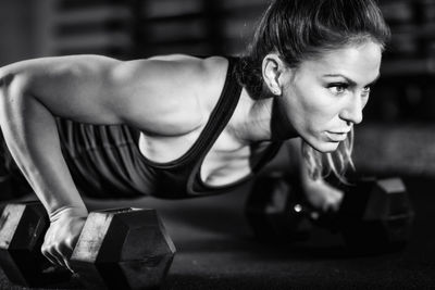 Cross training. young woman exercising with dumbbells