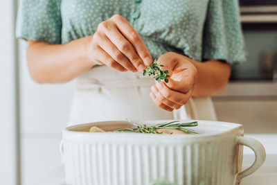 Female hands holding thyme for seasoning food