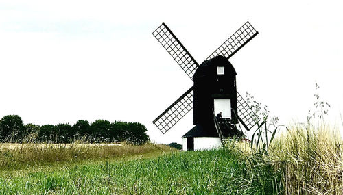 Traditional windmill on field against sky