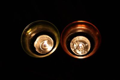 Directly above shot of illuminated light bulb against black background