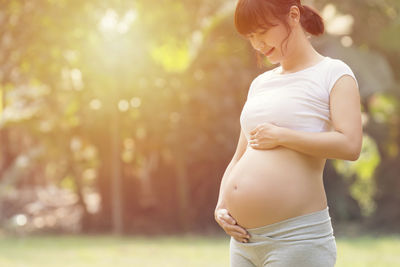 Beautiful pregnant woman standing outdoors