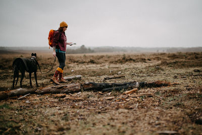 Rear view of woman walking on field