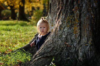 Portrait of boy on tree trunk