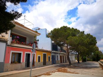 Buildings by street against sky
