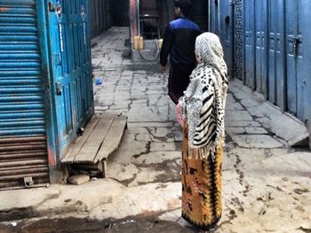 Full length of woman standing by building