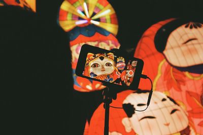 Portrait of man photographing illuminated lighting equipment