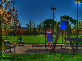 Playground in park against blue sky