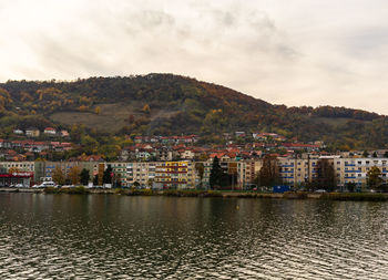 River by townscape against sky in town