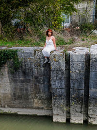 Full length of woman sitting by plants