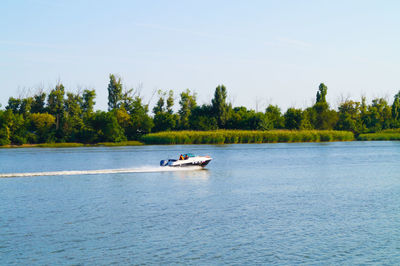 Boat sailing in river against sky