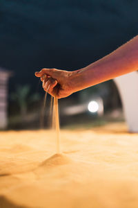 Crop hand spilling dry sand