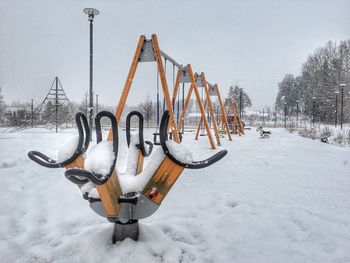 Snow covered playground against sky