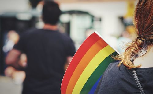 Rear view of woman with rainbow flag