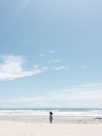 Mid distance view of woman at beach against sky