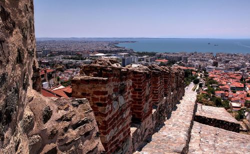 High angle view of townscape by sea against clear sky