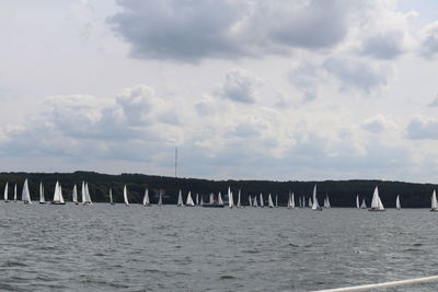 Panoramic shot of sailboats on sea against sky