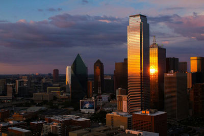 Skyscrapers in city against cloudy sky