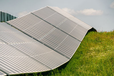 Solar, photovoltaic power station located on the hill. green grass and blue skies and white clouds