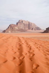 Sand dunes in desert against sky