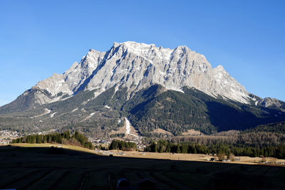 Scenic view of snowcapped mountains against clear blue sky