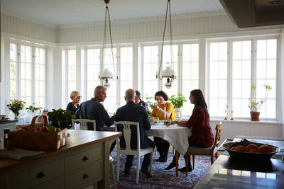 Friends having lunch in dining room at home during social gathering