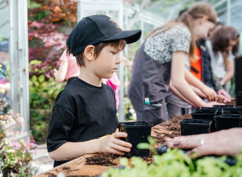 Children learning gardening by planting seedlings