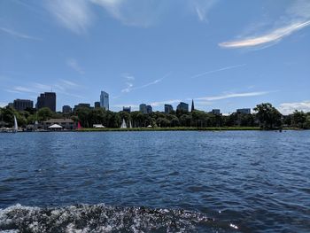 Scenic view of river by buildings against sky