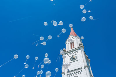 Low angle view of clock tower against blue sky