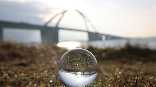 Close-up of crystal ball against sky