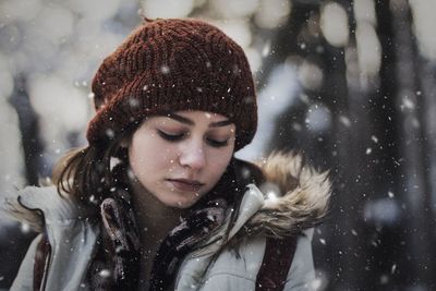 Woman looking down outdoors during snowfall