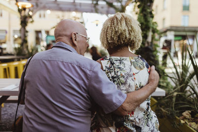 Rear view of senior couple sitting in cafe during vacation