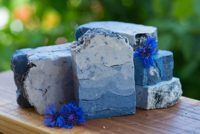 Dark blue handmade soap with blue flowers on a green background