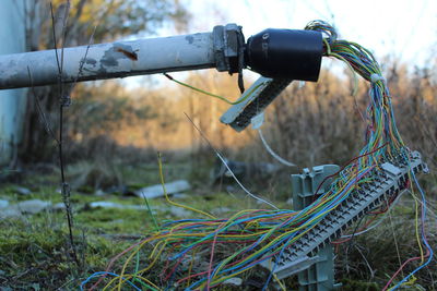 Close-up of fallen pole with cables on field