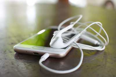 Close-up of smart phone with headphones on table