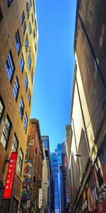 Low angle view of buildings against clear blue sky