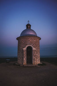 Building by sea against clear sky at dusk