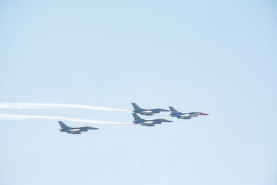 Low angle view of airplane flying against clear blue sky