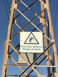 Low angle view of road sign against clear sky