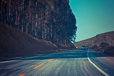 Road amidst trees against sky at night