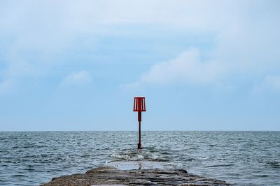 Lifeguard hut on sea against sky