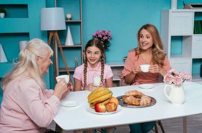 Young woman sitting with drink on table