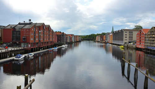 Canal amidst buildings in city against sky