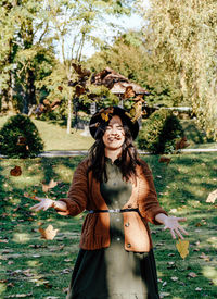 Portrait of smiling young woman standing against plants