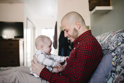 Father with daughter sitting on bed at home